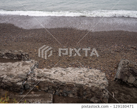 Old blocks of fortifications of the coast. Concrete structures on the shore. Protection against storms, waves and avalanches. 129180471