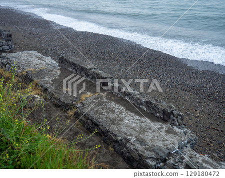 Old blocks of fortifications of the coast. Concrete structures on the shore. Protection against storms, waves and avalanches. Old blocks of fortifications of the coast. Concrete structures on the shore. Protection against storms, waves and avalanches. 129180472