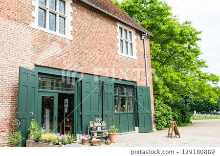 The shop is located in a historic red brick building with a deep green door in Osterley Park, a suburb of London. 129180889