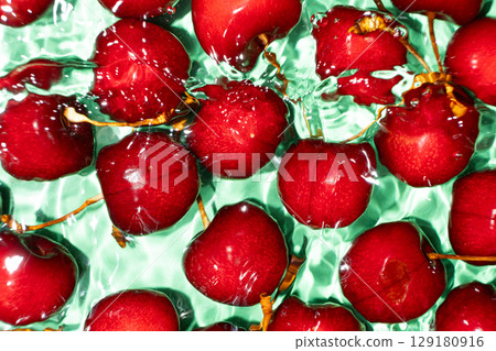 Ripe red sweet cherry in water close-up top view. 129180916