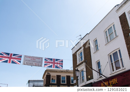 Union Jack flags hanging between historic brick buildings in Portobello, London 129181021