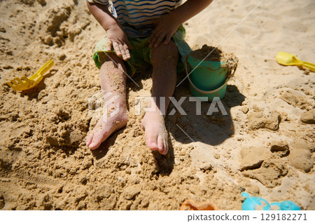 Child Playing With Sand Toys on a Sunny Beach 129182271