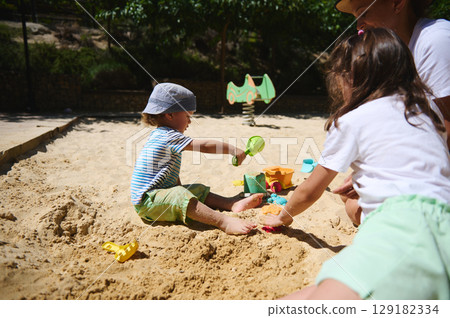 Children Enjoying Playtime Together at a Sunny Outdoor Playground Children Enjoying Playtime Together at a Sunny Outdoor Playground 129182334