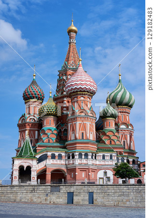 Majestic view of Saint Basil Cathedral with its colorful onion domes rising under a vivid blue sky in Red Square, showcasing intricate Russian architecture and historic cultural splendor 129182483