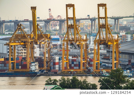 Background for cranes and industrial cargo ships in port at twilight. Background for cranes and industrial cargo ships in port at twilight. 129184254