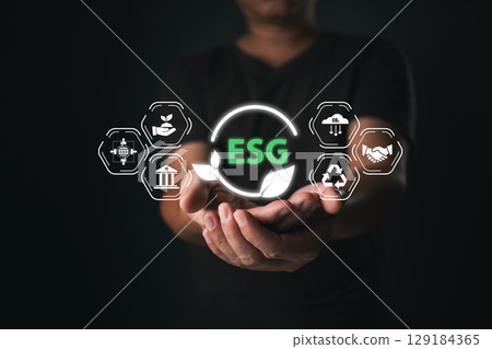 A person holds an icon symbol energy conservation, climate change awareness, eco-friendly investment, representing ESG principles, green business innovation, and sustainable development. 129184365