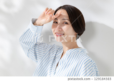 Woman standing in the sunshine 129184383