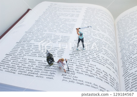 Miniature Golfers Playing on an Open Book Page in Creative Concept Miniature Golfers Playing on an Open Book Page in Creative Concept 129184567