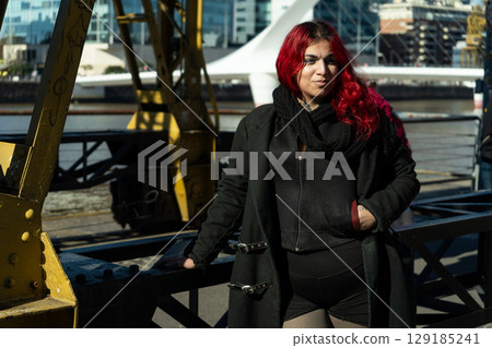 Young woman with dyed red hair posing near the woman's bridge in buenos aires 129185241
