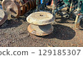 Close-up of old, rusty agricultural disc blades on soil, part of a vintage farm machine, symbolizing forgotten labor or rural history. 129185307