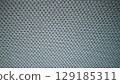 Close-up of soft, textured grey knitted fabric. Perfect for a cozy background or design element. 129185311