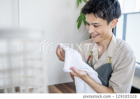 一位家庭主婦正在檢查他洗衣服的味道 129185328
