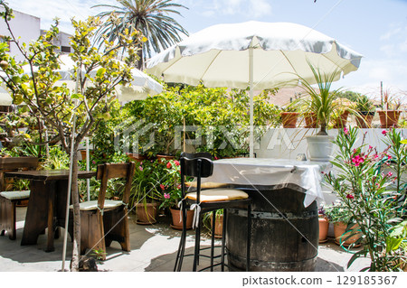 富埃特文圖拉島貝坦庫裡亞陽光明媚，餐廳露臺上擺放著白色遮陽傘和桌子 129185367