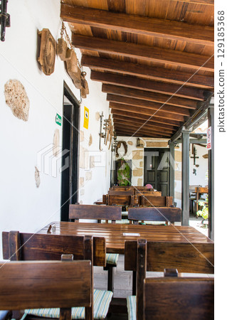 富埃特文圖拉島貝坦庫裡亞的露臺旁有一家明亮的餐廳，牆壁是白色的，配有木桌椅 129185368