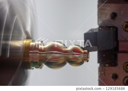 Close up scene the CNC lathe machine forming cutting the brass material shaft parts. Close up scene the CNC lathe machine forming cutting the brass material shaft parts. 129185686