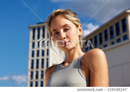 Confident Woman in Urban Setting Under Clear Blue Sky 129186247