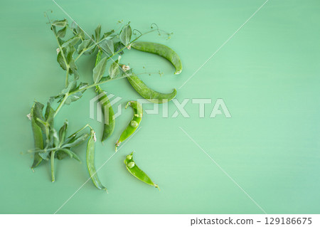 Green pea pods and leaves on background 129186675