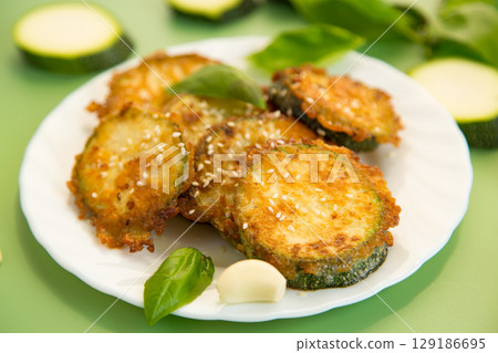 Golden zucchini slices in a crispy homemade breading Golden zucchini slices in a crispy homemade breading 129186695