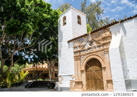A white-walled church surrounded by trees in bright sunlight in Betancuria, Fuerteventura A white-walled church surrounded by trees in bright sunlight in Betancuria, Fuerteventura 129186925