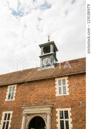 A clock tower on the red roof of a historic building under a clear sky in Osterley Park on the outskirts of London A clock tower on the red roof of a historic building under a clear sky in Osterley Park on the outskirts of London 129186979