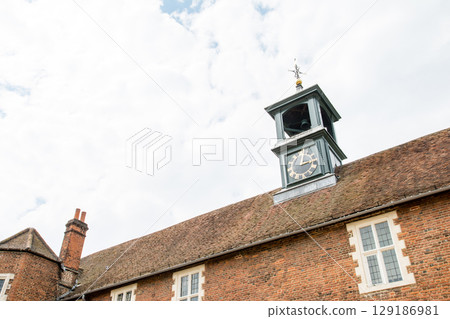 A clock tower on the red roof of a historic building under a clear sky in Osterley Park on the outskirts of London A clock tower on the red roof of a historic building under a clear sky in Osterley Park on the outskirts of London 129186981