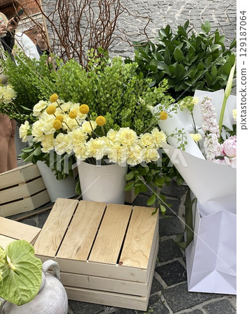 Bouquet of fresh flowers with greenery on display at outdoor market 129187064