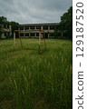 Overgrown abandoned schoolyard and rusty soccer goal 129187520