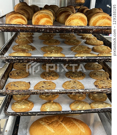 Delicious freshly baked bread and cookies lined up in a bakery Delicious freshly baked bread and cookies lined up in a bakery 129188195