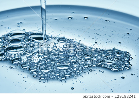 Shampoo or shower gel is poured from above and shows a bubbly texture. Shampoo or shower gel is poured from above and shows a bubbly texture. 129188241