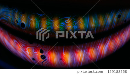 Soap oil swirl. Colorful flare. Gasoline paint floating on dark black liquid. Defocused curve lens light glow on abstract art background. 129188368