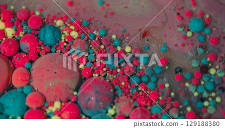 Drop flow. Color bubbles. Defocused pink blue yellow sparkling ink water oil droplets shimmer pigment floating on abstract background. 129188380