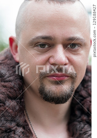 Intense Portrait of a Bearded Man in Fur Collar, Close-up, Gray and Brown Tones, Dramatic Lighting, Serious Expression, Studio Shot, Realistic Style Intense Portrait of a Bearded Man in Fur Collar, Close-up, Gray and Brown Tones, Dramatic Lighting, Serious Expression, Studio Shot, Realistic Style 129188427