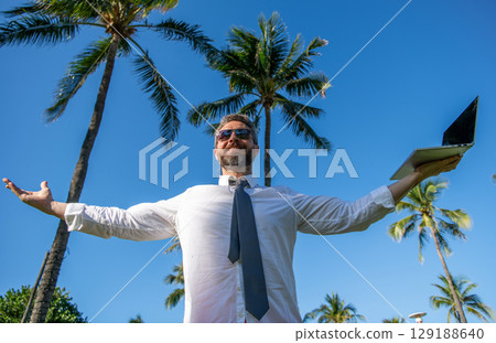 Online freelance work. Successful businessman worker with laptop. Business man using laptop in palm. Business trip success. Man freelance worker online. Businessman on summer. Executive travel perks 129188640
