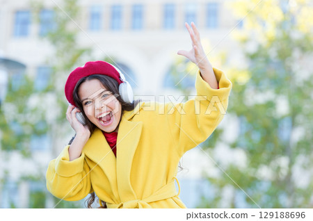Little girl listening music enjoy favorite song. Girl with headphones urban background. Positive influence of music. Child girl french style outfit enjoying music. Childhood and teenage music taste Little girl listening music enjoy favorite song. Girl with headphones urban background. Positive influence of music. Child girl french style outfit enjoying music. Childhood and teenage music taste 129188696