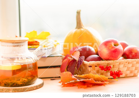 Autumn still life, warm tea, apples and books on the windowsill. Cozy autumn. Autumn still life, warm tea, apples and books on the windowsill. Cozy autumn. 129188703