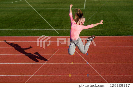 Being energetic is the new you. Energetic child jump on athletics track. Active lifestyle Being energetic is the new you. Energetic child jump on athletics track. Active lifestyle 129189117