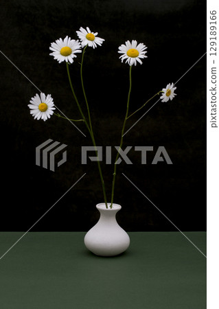 Still life with a bouquet of daisies in a white vase Still life with a bouquet of daisies in a white vase 129189166