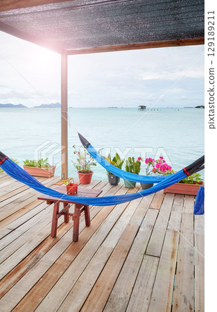 Hammocks on a wooden platform over water, holiday relaxation concept. 129189211
