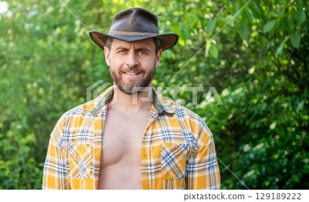 macho man in cowboy hat. macho man in checkered shirt. western macho man wearing hat. copy space 129189222
