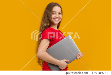 smiling girl with laptop on yellow background 129189282