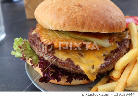 Delicious Cheeseburger with French Fries on a Plate Delicious Cheeseburger with French Fries on a Plate 129189444