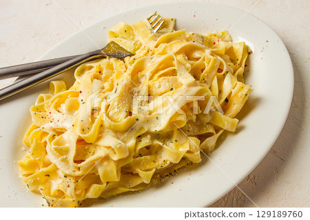 Fettuccine, tagliatelle, in creamy garlic sauce, Italian traditional cuisine, pasta carbonaro, Fettuccine, tagliatelle, in creamy garlic sauce, Italian traditional cuisine, pasta carbonaro, 129189760