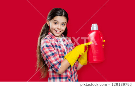 girl household presenting detergent isolated on red. girl household with detergent in studio. 129189793
