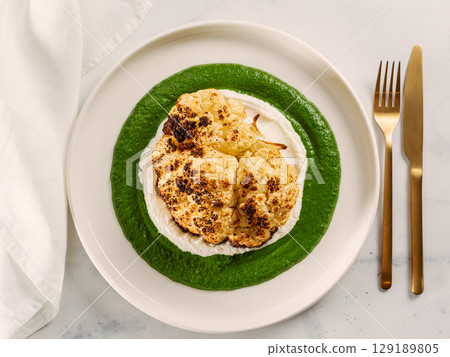 Cauliflower steak with green and white puree. Grilled cauliflower as vegan and vegetarian food concept. Healthy food ideas and menu. 129189805