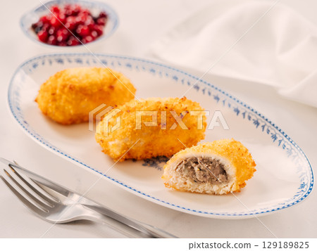 Crispy breaded cutlet. Three perfect crunchy cutlet on plate. Delicious fried cutlets in bread crumbs made from beef, pork, chicken meat or fish 129189825