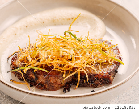 Beef or pork steak with shoestring fries onion and potatoes puree. Restaurant style plating beefsteak. Food and cuisine concept. Delicious pork steak. BBQ rib beefsteak or tender pork steak 129189833