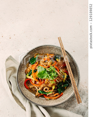 Asian noodles with meat and vegetables. Stir fry noodles with vegetables and beef, pork or chicken. Plate of asian buckwheat soba noodles with vegetables and chicken. 129189852