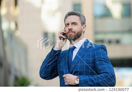 Businessman using phone. Man phone conversation in city. Businessman talking on phone. Businessman in front office. Social network. Hispanic business man with phone at office building. Agile business Businessman using phone. Man phone conversation in city. Businessman talking on phone. Businessman in front office. Social network. Hispanic business man with phone at office building. Agile business 129190077