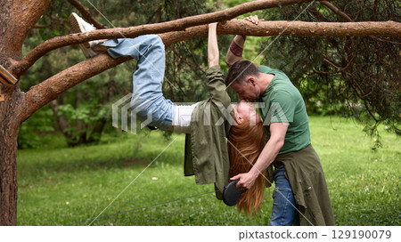 Couple enjoying a playful moment together in a lush green park Couple enjoying a playful moment together in a lush green park 129190079