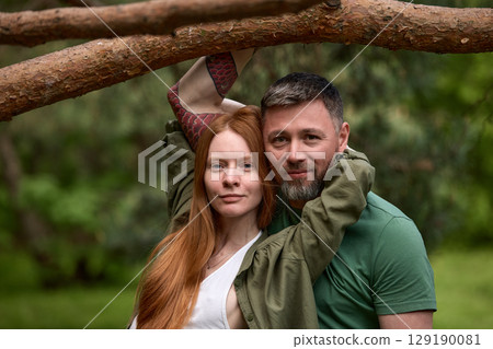 Couple Posing Together Under a Tree Branch in a Natural Setting 129190081
